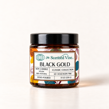 Load image into Gallery viewer, Black Gold 8 oz soy candle centered on ivory background in amber glass jar with Classic Collection label