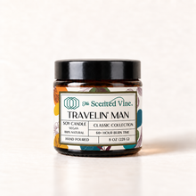 Load image into Gallery viewer, Travelin Man 8 oz soy candle in amber glass jar with Classic Collection label on ivory background